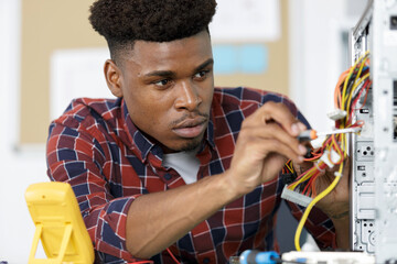 man is repairing broken pc with a screw driver