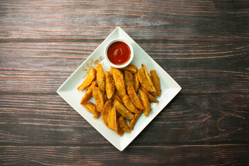 Potato Wedges served in plate isolated on wooden background top view of bangladeshi food