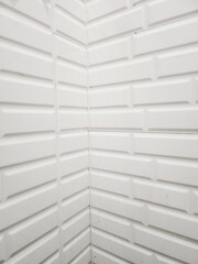 Interior corner view of white wall panels.