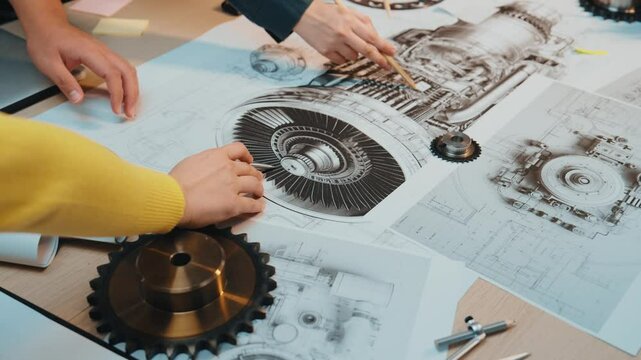 Two engineers discuss and analyze mechanical components and technical drawings in a collaborative workspace, showcasing precision and innovation in design. SACTR