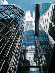 Naklejka premium Modern skyscrapers reflect clouds in a vibrant urban landscape