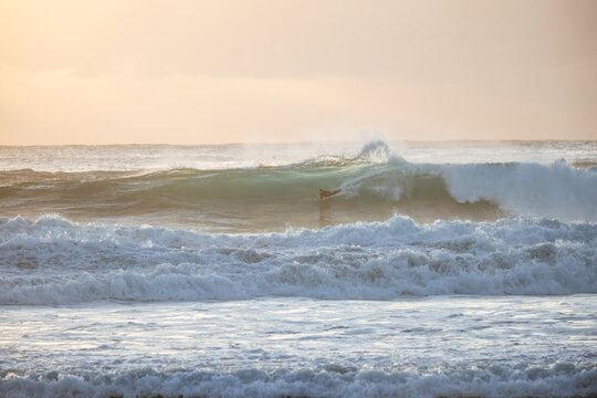 Bodysurfer catches sunrise wave at Manly Beach, Australia
