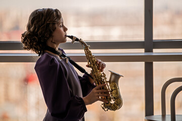 Young Girl Playing Saxophone by Window