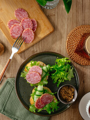 sandwich with sausage on bread and fresh cucumber and herbs