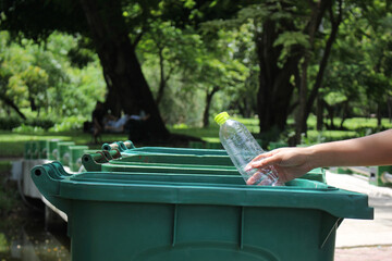 Recycling.Woman hand throwing bottle water into trash can