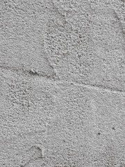 Closeup of a gray concrete wall with rough and textured surface.