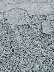 Closeup of a weathered concrete wall with rough grey texture.