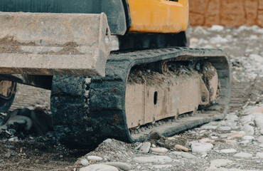 A dirty yellow and black construction vehicle with a large black tire