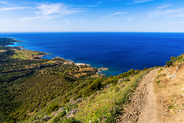 Winding footpath through rugged hills overlooking spectacular coast of Cyprus. Trail offers sweeping vistas of shimmering sea and steep coastal cliffs