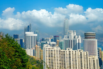 View of skyscrapers and tall buildings famous city of Hong Kong on the road to the peak of Victoria among forests