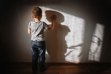 Little boy lonely depressed standing with back sitting on floor sad autism. autism spectrum...
