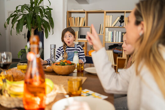 Family enjoying a meal together mother pointing at daughter