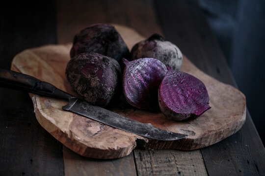 Fresh beetroots on a wooden board with a knife in a studio setting