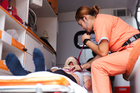 Nurse measuring vital signs of a patient in an ambulance during an emergency.