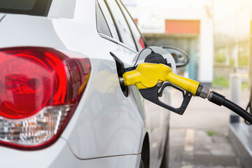 Transportation and ownership concept - man pumping gasoline fuel in car at gas station. hight price...
