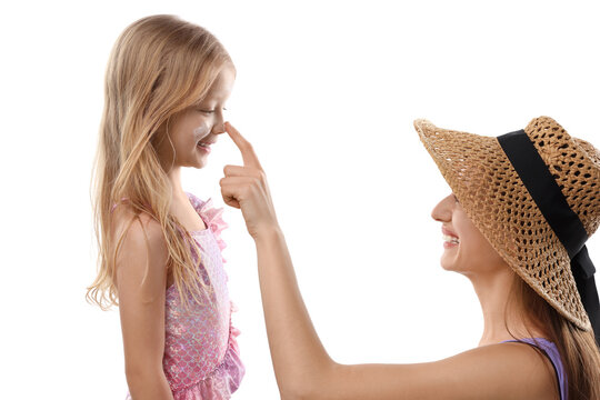 Smiling mother applying sun protection product onto her daughter's nose on white background - Powered by Adobe