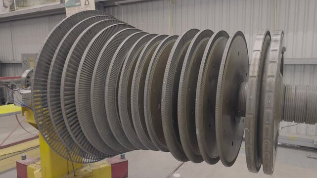 A steam turbine being turned manually in the open air