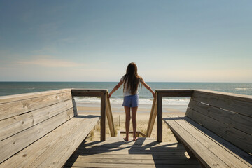 Profile tween girl standing on top boardwalk sunny blue sky Oute