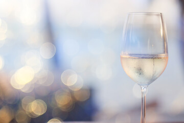 a glass of white wine, a background under the summer sun, a bokeh and sun glare, a blurred abstract background