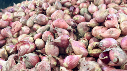 A lot of organic onions for sale. Spicy vegetables. Kitchen ingredients on sale in an Asian supermarket. Organic seasoning vegetables