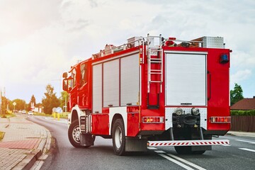 Fire truck driving through suburban area on cloudy day.