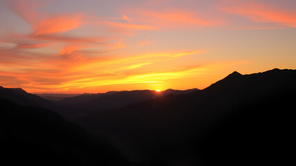 A vibrant sunset casting a golden glow over a mountain range and a peaceful valley.
