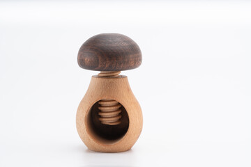 Wooden mushroom-shaped nutcracker with a screw mechanism, photographed on a white background,...