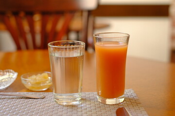 glass of water and glass of vegetable mix juice on the table in morning