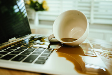Morning mishap: hot coffee spills over office laptop and documents on a desk, causing wet stains, electronic hazard, and frustration.