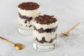 Vegan dessert cream with shea butter and chocolate biscuit, layered dessert in glasses on a light background. Black forest trifle.