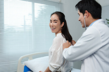 Obraz premium Doctor examining patient's lungs with stethoscope in hospital room