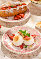 cottage cheese cheesecakes with strawberries, croissant and porridge with strawberries. breakfast in the restaurant