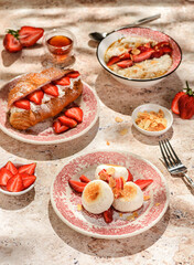 cottage cheese cheesecakes with strawberries, croissant and porridge with strawberries. breakfast...