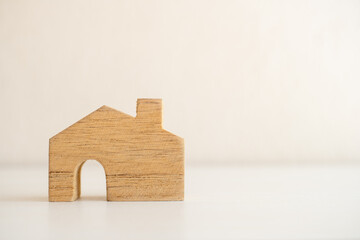 Minimalist wooden house model placed on a clean white surface