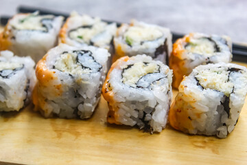 close up of several pieces of sushi on a wooden background