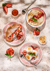 cottage cheese cheesecakes with strawberries, croissant and porridge with strawberries. breakfast...