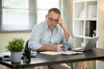 A businessman is sitting at his desk working.