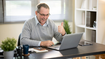 Obraz premium Businessman discussing work via video conference at his desk.