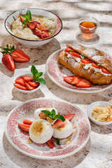 cottage cheese cheesecakes with strawberries, croissant and porridge with strawberries. breakfast...