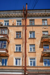 Fire escape on the facade of an old apartment building on a spring day