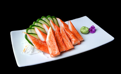 Imitation crab sashimi with cucumber slices and wasabi on white plate