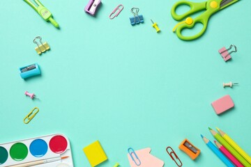 Various colorful school supplies including paints, scissors, pencsils on a color background. Space for text