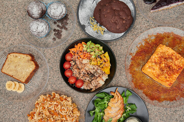 A table with many different types of food on it. There are plates with sandwiches, salads, and other dishes