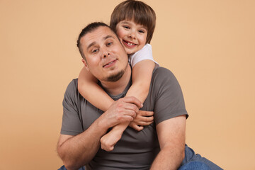 Fototapeta premium Father and his son on beige background