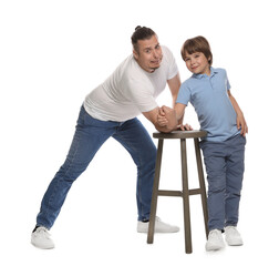 Father with his son arm wrestling on white background