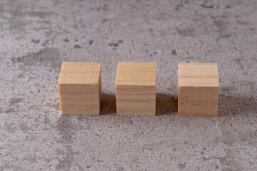 Three wooden blocks on a textured surface