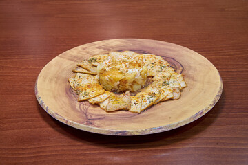 A plate of food with a wooden plate. The plate has a variety of food items on it