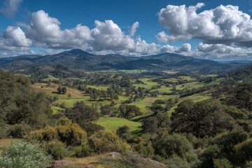Expansive view of rolling hills with lush greenery and dramatic clouds over a serene valley in the countryside