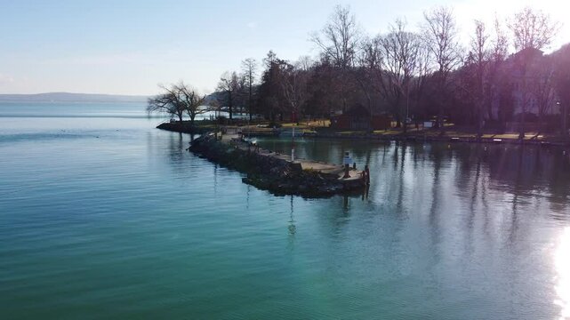 Aerial sunset view of Kis Mohle pier at Lake Balaton with soft reflection and silhouetted trees