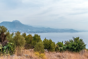 Scenic view from Alanya Castle, Turkey, overlooking the serene coastline and distant mountains. Lush greenery and Mediterranean Sea create a peaceful landscape, offering a glimpse into nature's beauty